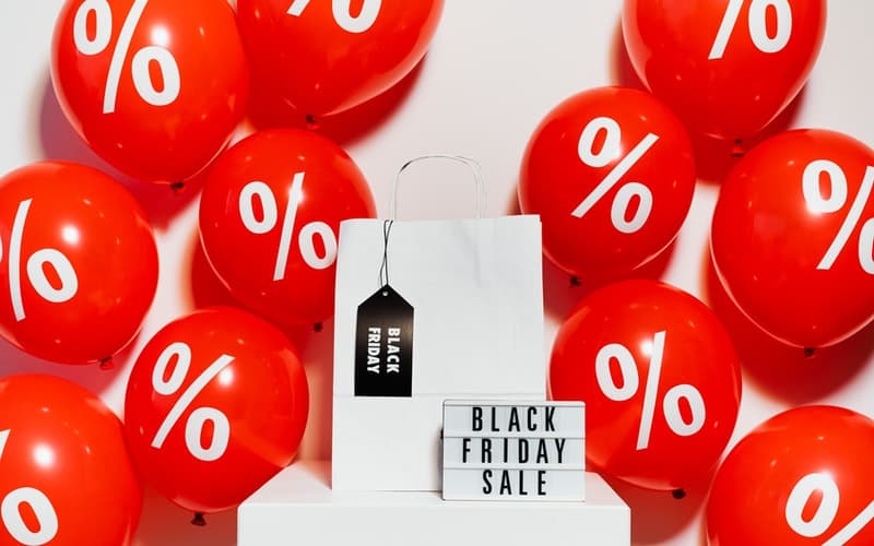 A Black Friday sign with red balloons