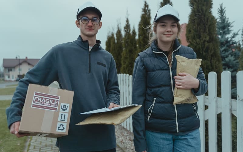 two people holding packages to mail