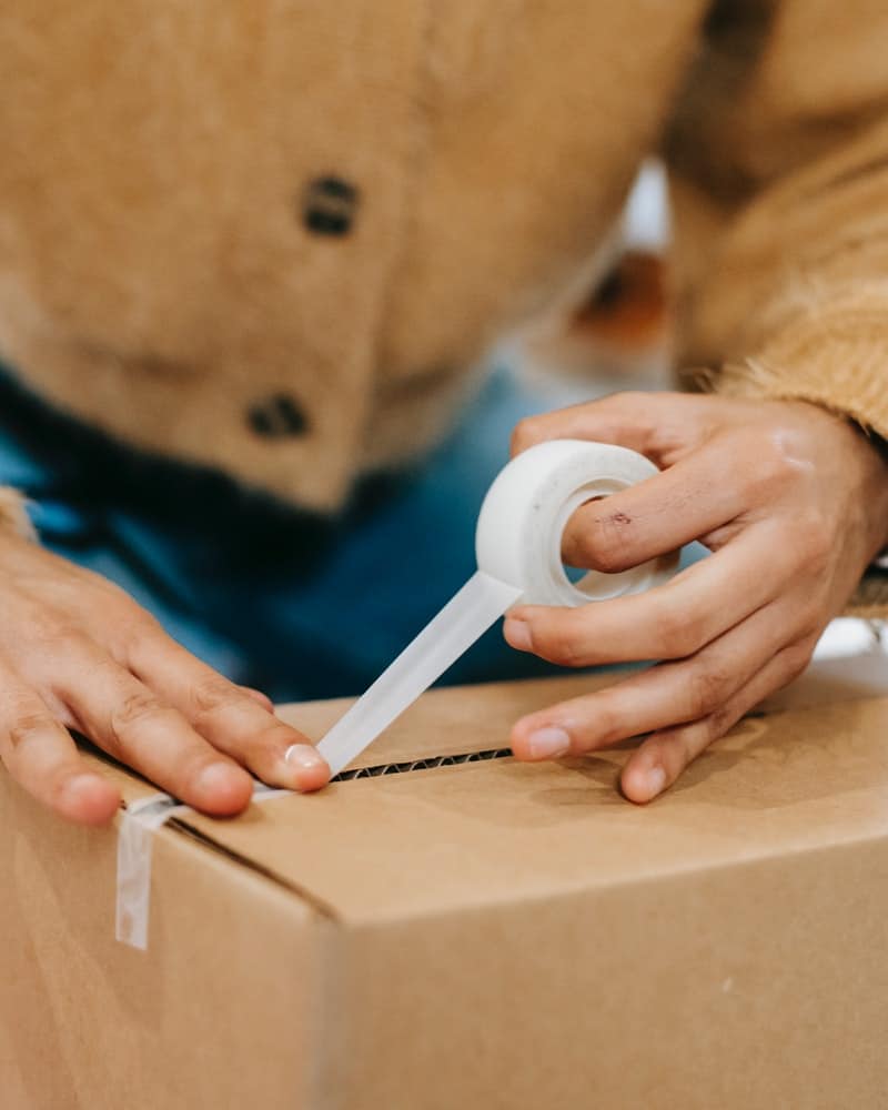 a person sealing a box with tape