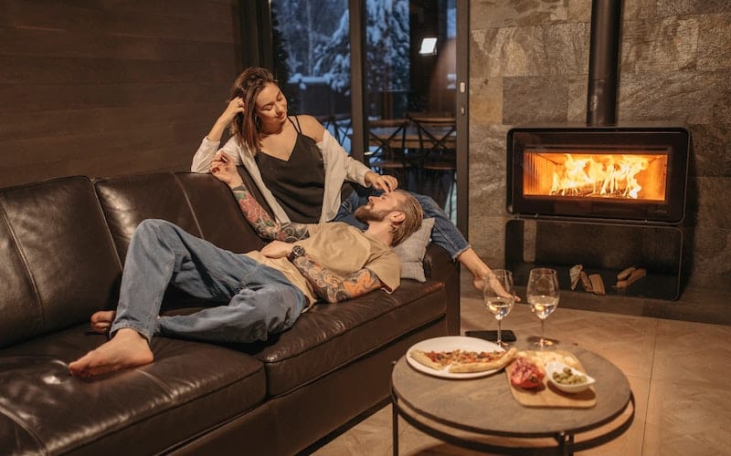 a couple relaxing in front of a fireplace