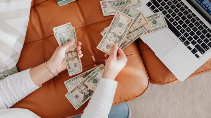 woman with money and a laptop